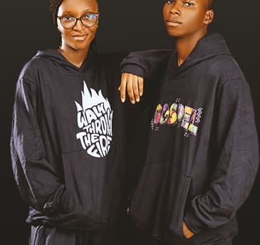 Two models in black ADULLAM hoodie sets with “Walk Through the Fire” and “Gospel” graphics.